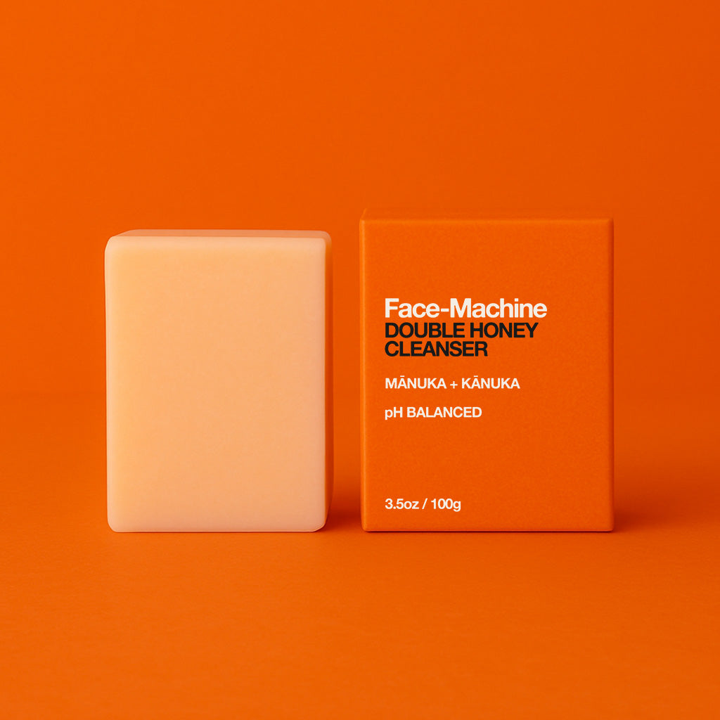 Bar of soap and its packaging on an orange background. Orange box of Face-Machine Double Honey Cleanser on an orange background. facial cleanser, clean skin, skin repair, gift for wife, skincare routine, gentle face wash, hydrating cleanser, anti-aging skincare, daily cleanser, sensitive skin care, skin revitalization, luxury skincare gift, natural cleanser, deep pore cleanse, skin renewal, manuka honey